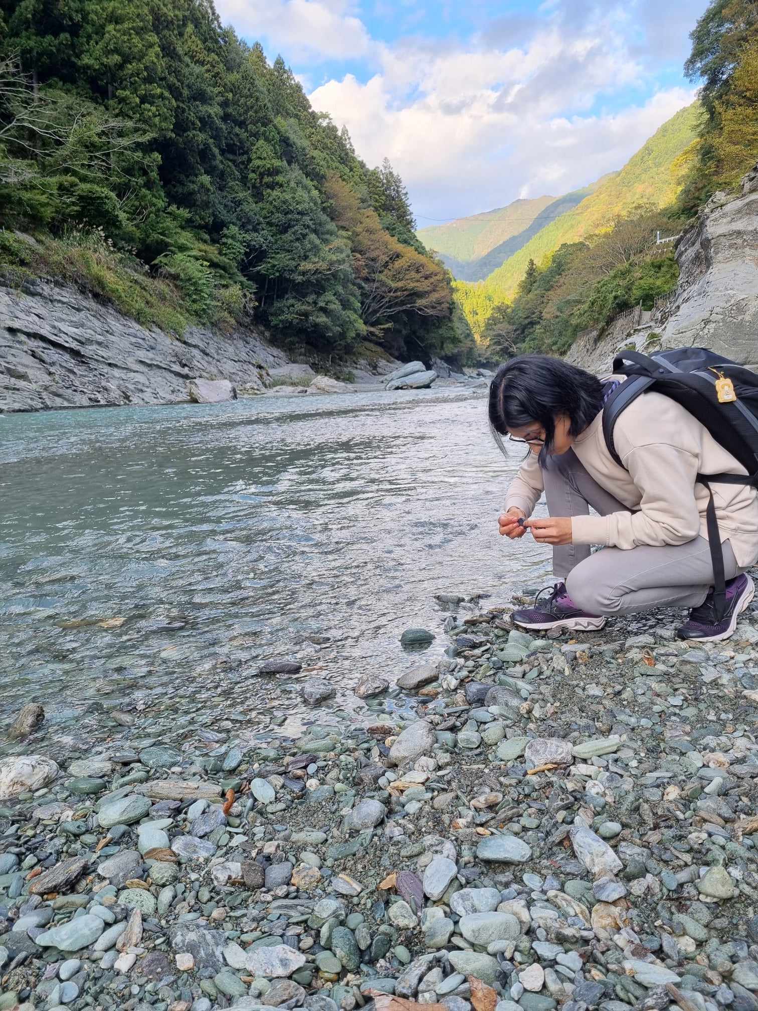 Picture of woman picking up rocks from river